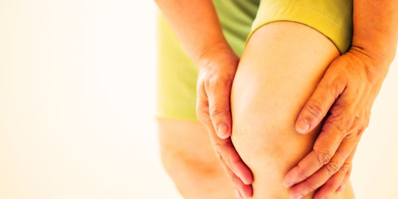 A person holding one knee that is slightly bent