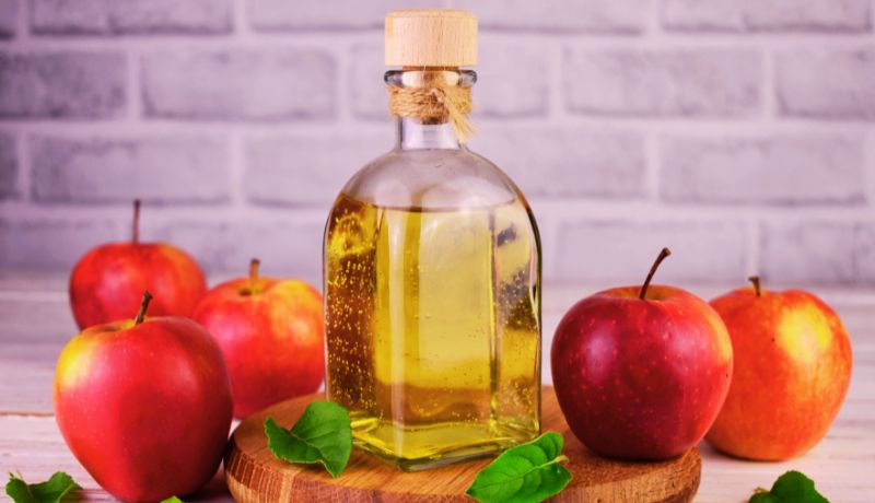 A Bottle of Apple Cider Vinegar with Apples